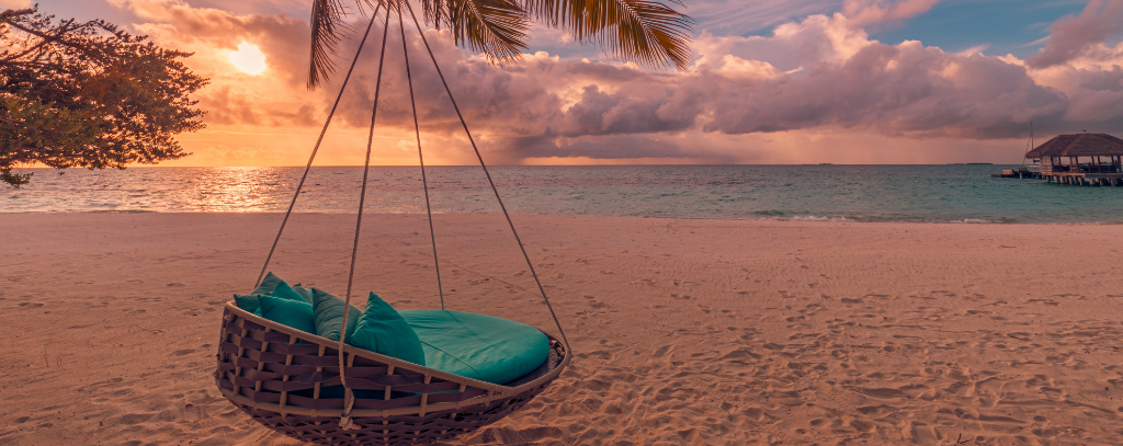 A swing chair overlooking the sea at sunset